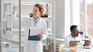female-researcher-with-clipboard-biotechnology-laboratory-male-colleague