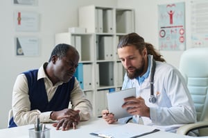 young-confident-clinician-with-tablet-making-presentation-patient
